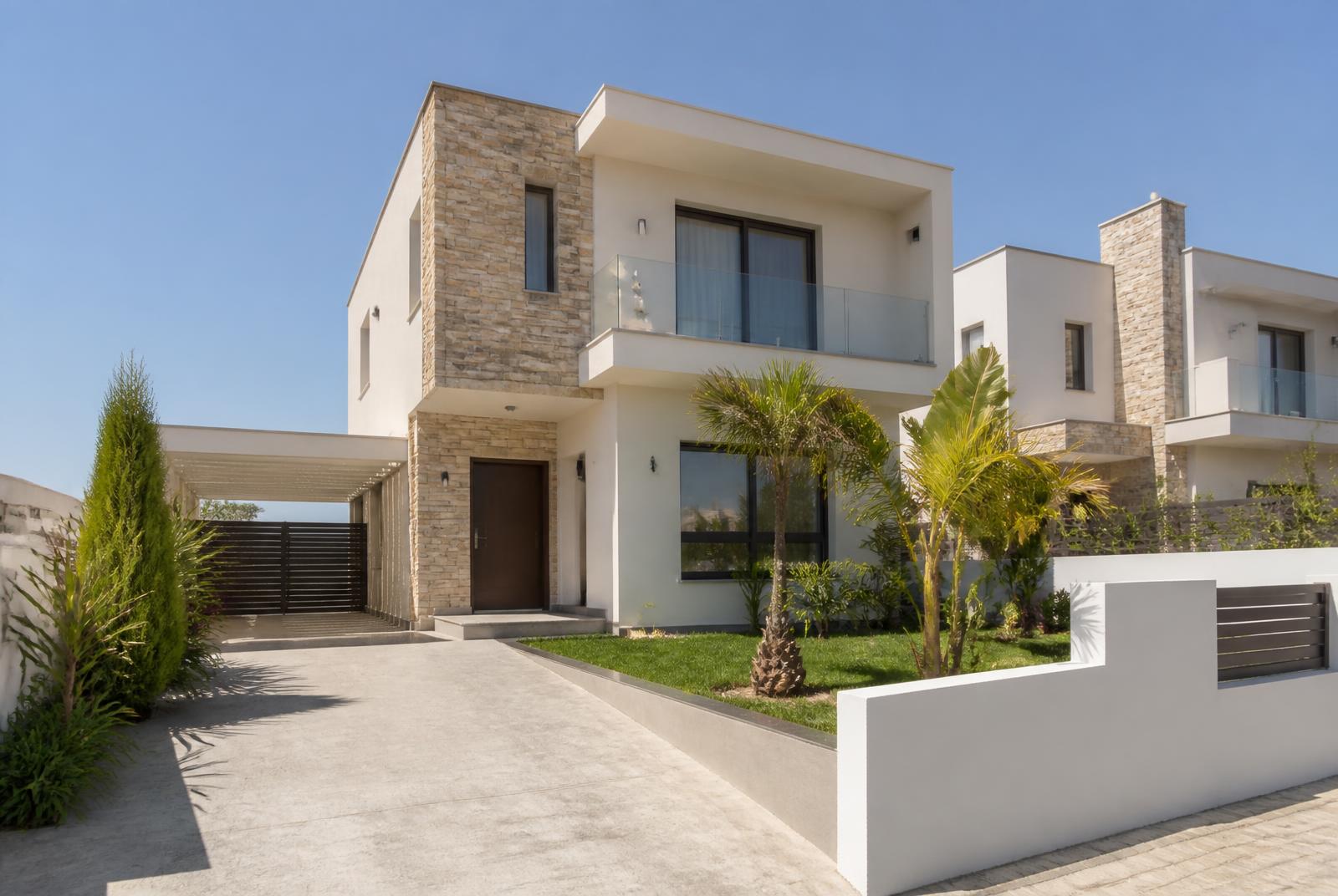 Nieuw gebouwde woning in een woonwijk van Larnaca met lichte gevel, natuursteen accenten en jonge palmen