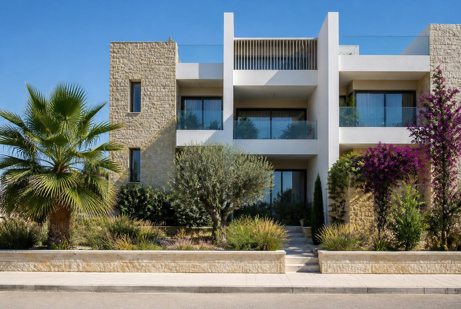 Modern appartementengebouw in Paphos met natuurstenen gevel, ruime balkons en mediterrane beplanting